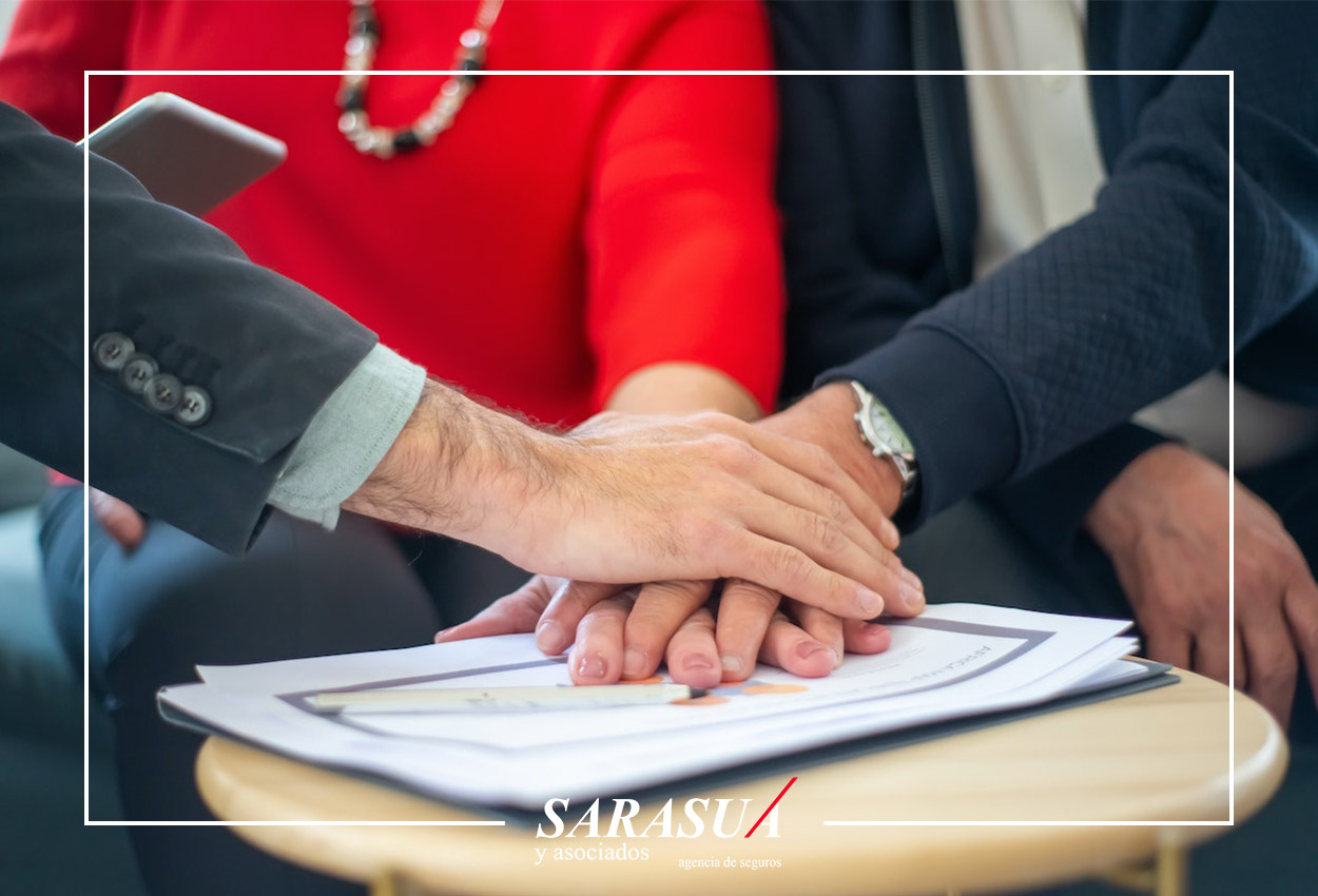 Mediador de seguros con sus clientes juntando manos